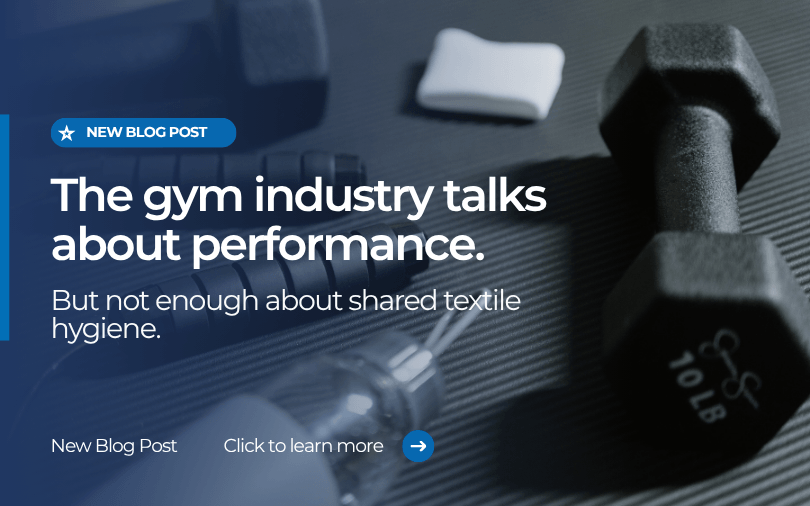 Gym equipment including dumbbells and exercise mats, representing the importance of shared textile hygiene in fitness facilities.